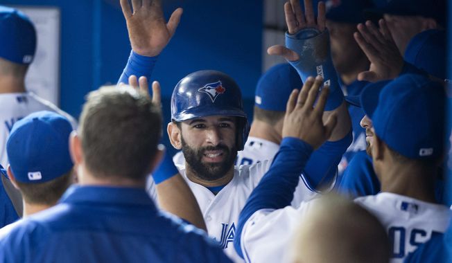 Toronto Blue Jays&#x27; Jose Bautista celebrates in the dugout after scoring on an Edwin Encarnacion two-run single against the Tampa Bay Rays in the first inning of a baseball game in Toronto on Wednesday, May 28, 2014. (AP Photo/The Canadian Press, Darren Calabrese)