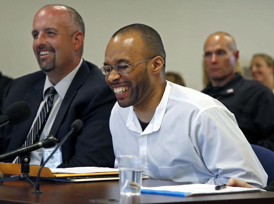 Frederick Christian laughs during a light moment at a hearing before the state's parole board in Natick, Mass., Thursday, May 29, 2014. Christian, who has been in prison for twenty years for a premeditated robbery which resulted in two dead and one injured, is appealing for release after Massachusetts' highest court struck down mandatory life sentences for juveniles in December. At left is his attorney Joe Mulhern. (AP Photo/Elise Amendola)
