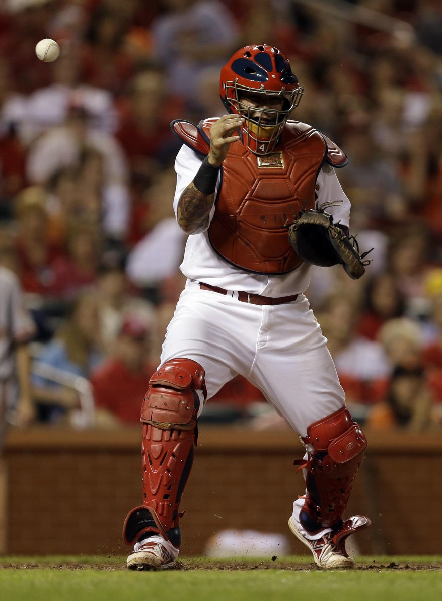A ball thrown by St. Louis Cardinals center fielder Peter Bourjos gets past Cardinals catcher Yadier Molina allowing San Francisco Giants' Gregor Blanco to score during the eighth inning of a baseball game, Thursday, May 29, 2014, in St. Louis. Bourjos was charged with a throwing error on the play. (AP Photo/Jeff Roberson)
