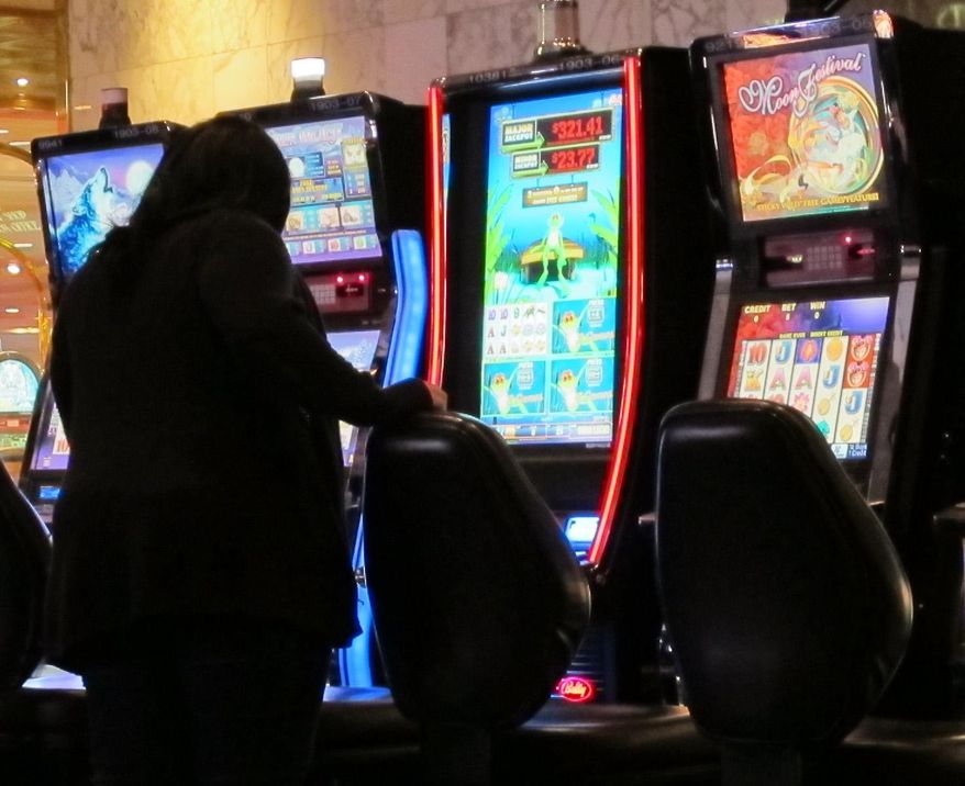 In this Jan. 12, 2014 photo, a woman gets up from a bank of slot machines minutes before the Atlantic Club Casino Hotel in Atlantic City N.J. shut down. On Thursday May 29, 2014, the property was sold to a Florida company that plans to run it as a non-gambling facility. (AP Photo/Wayne Parry)