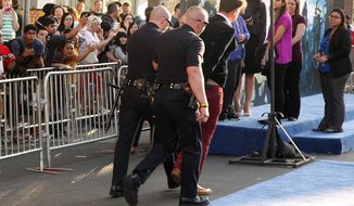 Journalist Vitalii Sediuk is walked off carpet in handcuffs after allegedly attacking Brad Pitt at the world premiere of &amp;quot;Maleficent&amp;quot; at the El Capitan Theatre on Wednesday, May 28, 2014, in Los Angeles. Sediuk’s antics have left him with fewer friends in the entertainment world after his publicist and television station cut ties with him over pranks that have once again landed the 25-year-old in handcuffs. He’s kissed Will Smith in Moscow, tried to steal Adele’s spotlight at the Grammys, dove under America Ferrera’s dress at Cannes and now accosted Pitt on the red carpet of a Hollywood premiere. (Photo by Matt Sayles/Invision/AP)