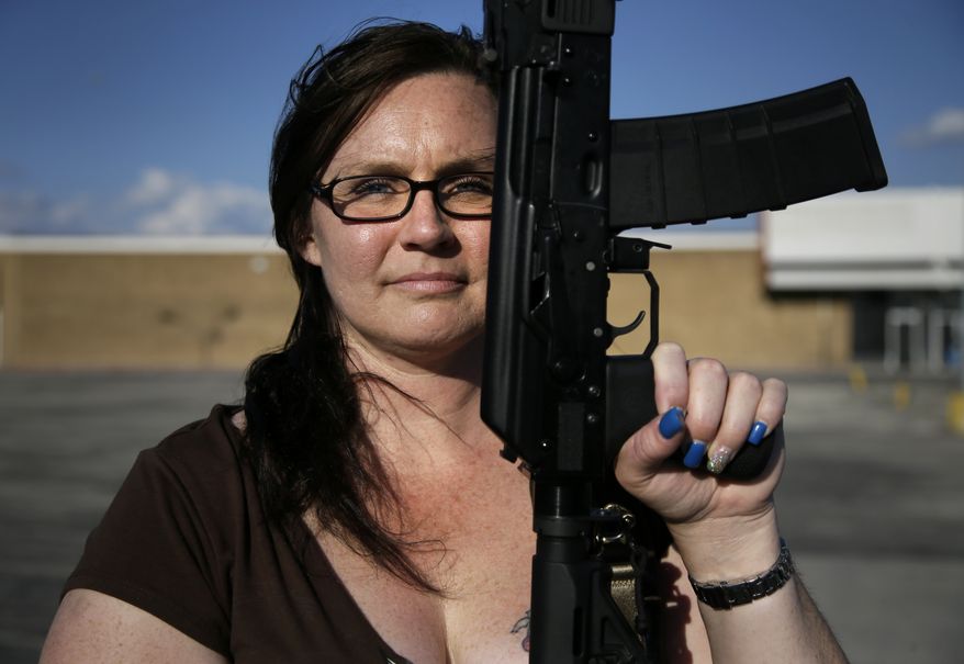 Tara Cowan of Euless, Texas, a member of Open Carry Tarrant County, poses for a portrait with a Saiga 556 rifle as she and members of the group Open Carry Tarrant County gathered for a demonstration, Thursday, May 29, 2014, in Haltom City, Texas. North Texas gun rights advocates are suing the city of Arlington for amending an ordinance that they claim is discriminatory and infringes upon free speech rights, in the latest sign of growing tensions among gun activists and government forces in Texas. (AP Photo/Tony Gutierrez)