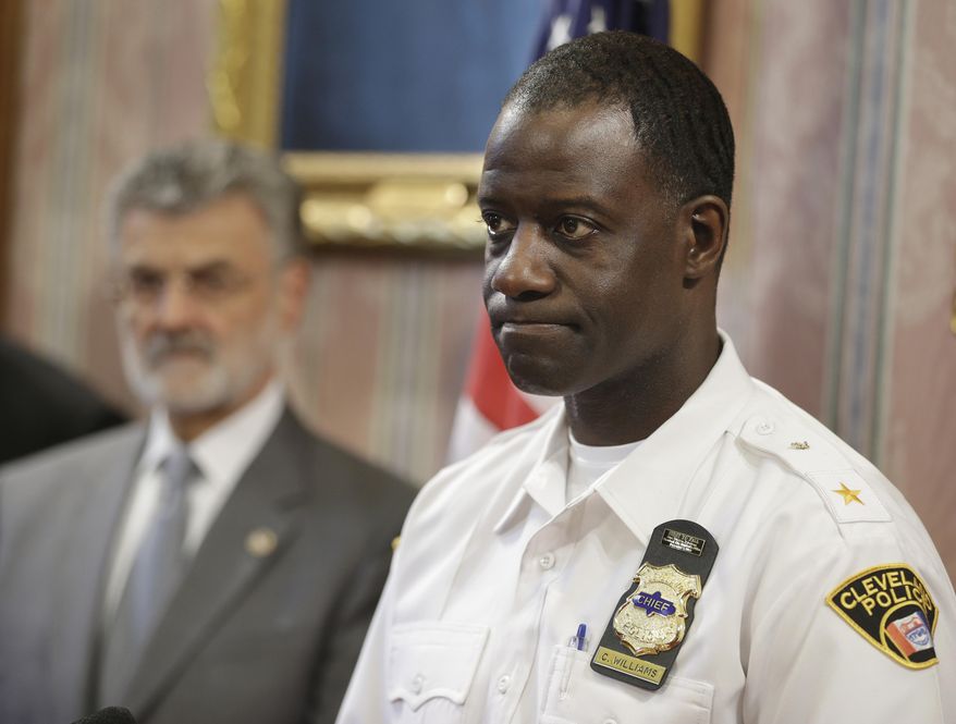 Cleveland Police Chief Calvin D. Williams, right, makes a statement regarding the grand jury announcement of the deaths of Timothy Russell and Malissa Williams Friday, May 30, 2014, in Cleveland. Cleveland Mayor Frank Jackson, left, listens. A grand jury on Friday indicted six police officers involved in a November 2012 car chase that ended in the deaths of two unarmed people, was decried by critics as a racially motivated execution and is part of a wide-ranging federal investigation. The grand jury indicted a patrol officer on two charges of manslaughter and five supervisors on charges of dereliction of duty for failing to control the chase. (AP Photo/Tony Dejak)