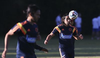 Colombia&#39;s player Radamel Falcao, right, trains with teammate Eder Alvarez Balanta in Buenos Aires, Argentina, Wednesday, May 28, 2014. Colombia&#39;s national soccer team is hoping Falcao will be able to play at the World Cup after his knee injury. Brazil is hosting the international soccer tournament starting in June. (AP Photo/Sergio Llamera)