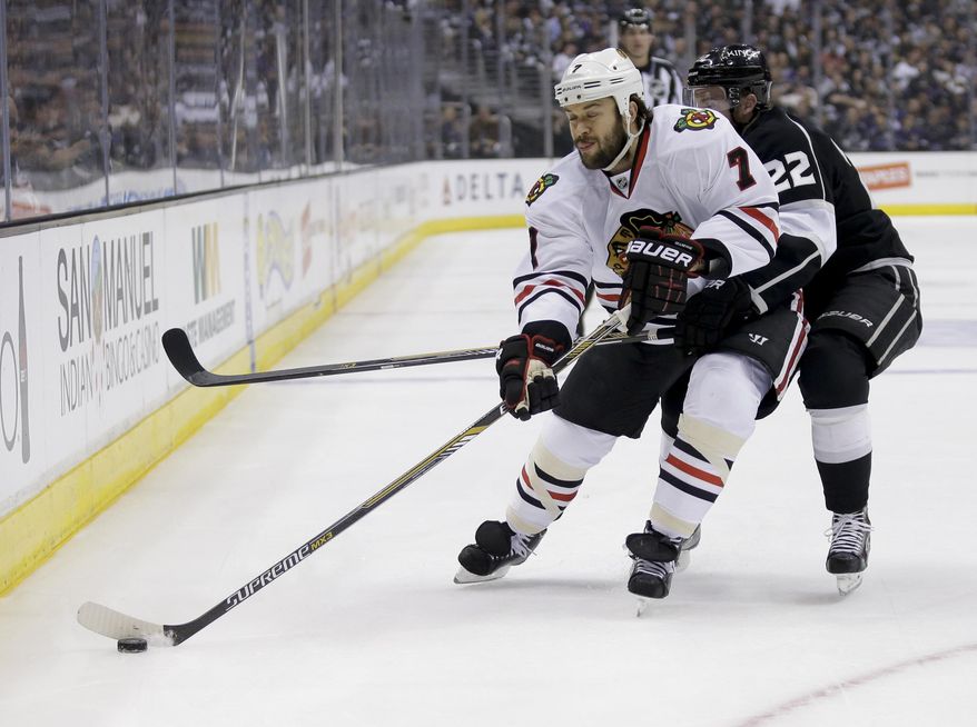 Chicago Blackhawks defenseman Brent Seabrook, left, competes against Los Angeles Kings center Trevor Lewis for the puck during first period of Game 6 of the Western Conference finals of the NHL hockey Stanley Cup playoffs in Los Angeles, Friday, May 30, 2014. (AP Photo/Chris Carlson)