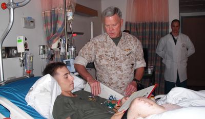 ADVANCE FOR WEEKEND EDITIONS, JUNE 1-2 - In this 2009 photo provided by Monster Energy, Jesse Williamson receives his purple heart citation from Commandant General Amos of the USMC at Walter Reed National Military Medical Center in Bethesda, Md. Next weekend, Williamson will attempt to become the first double amputee to compete in the Baja 500 off-road race through Mexico.  (AP Photo/Monster Energy)