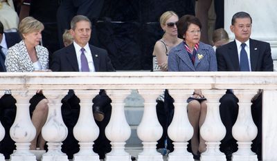 This photo taken May 26, 2014 shows outgoing Veterans Affairs Secretary Eric Shinseki and his wife Patricia Shinseki, right, and Deputy Veterans Affairs Secretary Sloan D. Gibson and his wife Margaret, left, attending a Memorial Day ceremony at Arlington National Cemetery in Arlington, Va. Gibson has been named to run the Veterans Affairs department on an interim basis while President Obama searches for another secretary after the resignation of Shinseki on Friday. (AP Photo/Jacquelyn Martin)