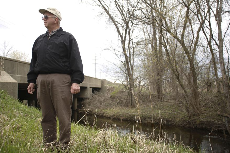 Richard Sharland from Plymouth stands on the edge of Johnson Creek on Thur., May 1, 2014 near the old Detroit House of Corrections facility in Plymouth. The creek is the dividing line between two parcels of land under question in reference to land acquisition between Plymouth and Wayne Townships. (AP Photo/Detroit Free Press, Tim Galloway)