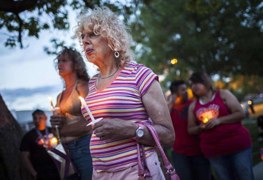 In this May 29, 2014 photo, Denee Mallon, center, joins a candlelight vigil organized by Albuquerque Pride in Albuquerque, N.M. A U.S. Department of Health and Services review board ruled Friday, May 30, in favor of Mallon, a 74-year-old Army veteran, whose request to have Medicare pay for her genital reconstruction was denied two years ago. The decision recognizes sex reassignment surgeries as a medically necessary and effective treatment for individuals who do not identify with their biological sex. (AP Photo/Craig Fritz)