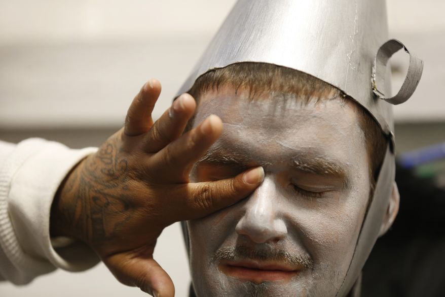 In this May 20, 2014 photo, Nathan Stump of Franklin County rehearses before the performance of "The Wizard of Oz" at the Chillicothe Correctional Institution in Chillicothe, Ohio. Stump is serving 12 years for the rape of a female child. The production is the idea of Darwin Secrest, a corrections officer with 20 years of experience Secrest wrote down the idea, put it in his pocket and eventually passed it on to the administration. The warden said go ahead and try. Secrest needed guys to try out. He needed to get them to read the original book, then watch the movie and then create a play that worked inside a prison. Only then would there be rehearsals and set-building and costume-sewing. (AP Photo/The Cincinnati Enquirer, Carrie Cochran) MANDATORY CREDIT; NO SALES