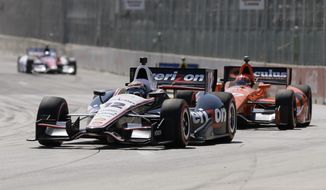 Will Power leads Simon Pagenaud through Turn 1 during the first race of the IndyCar Detroit Grand Prix auto racing doubleheader in Detroit, Saturday, May 31, 2014. (AP Photo/Carlos Osorio)