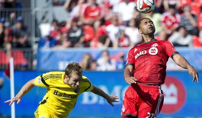 Toronto FC forward Luke Moore, right, heads the ball past Columbus Crew defender Tyson Wahl during the first half of an MLS soccer game in Toronto on Saturday, May 31, 2014. (AP Photo/The Canadian Press, Nathan Denette)