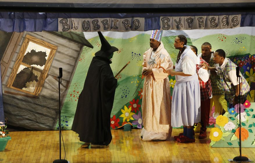 In this May 20, 2014 photo, Antoine Davis of Dayton, Ohio, left, who is serving a 25-year sentence for drug trafficking and attempted murder, center, performs as Glinda the Good Witch, center, and Joseph Sims of Greene County, who is serving 8 years for forgery, performs as Dorothy in the Ross Correctional Institution's rendition of the Wizard of Oz in Chillicothe, Ohio. The production is the idea of Darwin Secrest, a corrections officer with 20 years of experience Secrest wrote down the idea, put it in his pocket and eventually passed it on to the administration. The warden said go ahead and try. Secrest needed guys to try out. He needed to get them to read the original book, then watch the movie and then create a play that worked inside a prison. Only then would there be rehearsals and set-building and costume-sewing. (AP Photo/The Cincinnati Enquirer, Carrie Cochran) MANDATORY CREDIT; NO SALES