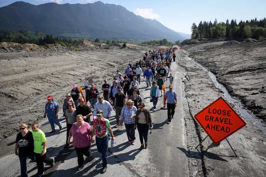 Hundreds of Oso, Darrington and Arlington, Wash. residents walk on State Route 530 near Oso, Wash. on Saturday, May 31, 2014 to pay tribute to those killed before the highway was reopened to cars. A little more than two months after the Oso mudslide destroyed a neighborhood and killed 43 people, the highway through the heart of the slide reopened to vehicle traffic. (AP Photo/seattlepi.com, Joshua Trujillo)