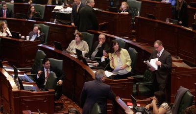 In this Friday, May 30, 2014 photo, Illinois Rep. Kelly Burke, D-Oak Lawn, bottom center, argues legislation while on the House floor during session at the Illinois State Capitol in Springfield Ill. The Illinois Legislature adjourned its spring session having passed a new state budget and other key measures but leaving other business undone. It’s possible some issues could come up again when lawmakers reconvene later this year or in January, a time known as the “lame duck” session because legislators who didn’t win re-election return to finish the last days of their term. (AP Photo/Seth Perlman)