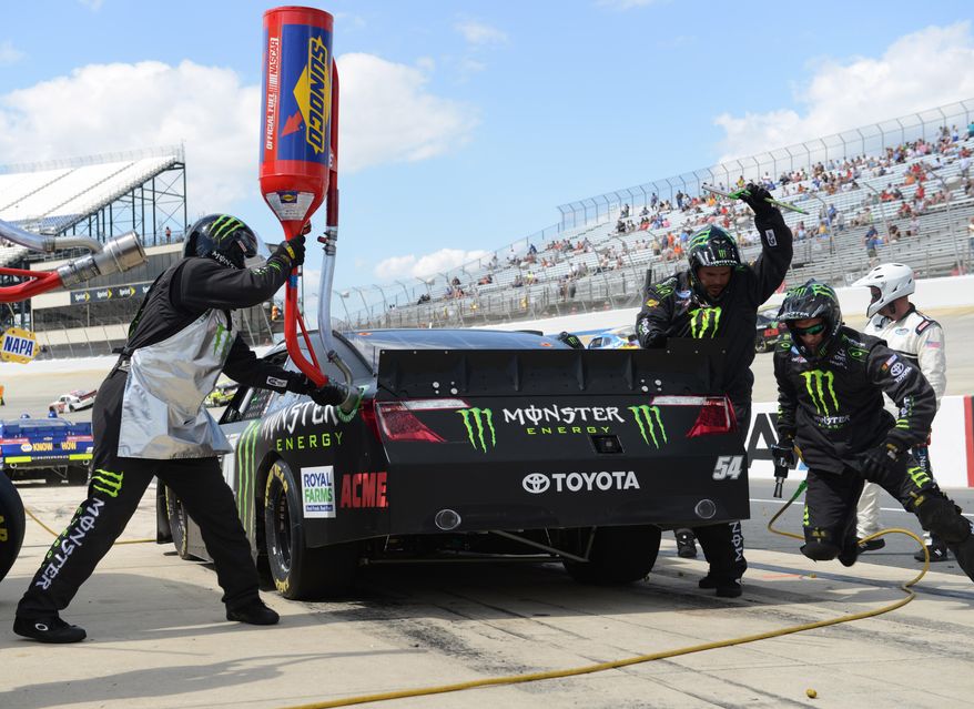Kyle Busch&#39;s pit crew works on his car during a pit stop during the NASCAR Nationwide series auto race, Saturday, May 31, 2014, at Dover International Speedway in Dover, Del. Busch won the race. (AP Photo/Molly Riley)