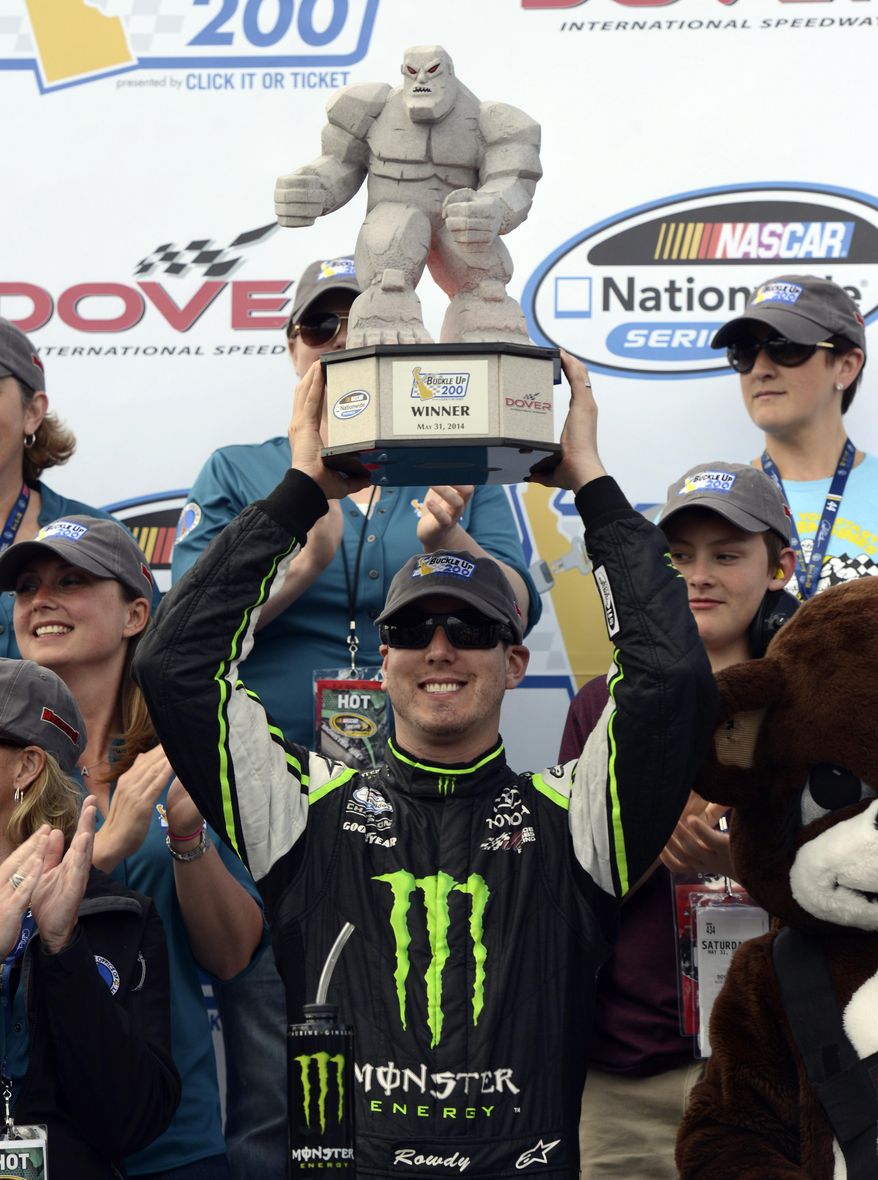 Kyle Busch holds up the trophy in Victory Lane after winning the NASCAR Nationwide series auto race, Saturday, May 31, 2014, at Dover International Speedway in Dover, Del. (AP Photo/Molly Riley)