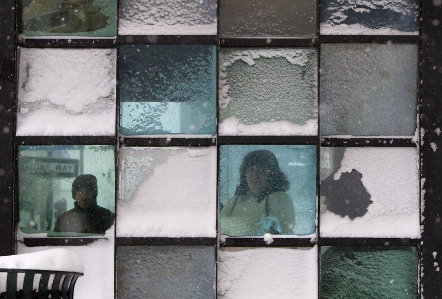 FILE - In this Feb. 8, 2013 file photo, riders wait in a bus stop where color-tinted windows collect snow during a storm in Portland, Maine. Less than 70 percent of 19-year-olds now have a drivers licence, down from 87 percent two decades ago, government figures show. (AP Photo/Robert F. Bukaty, File)