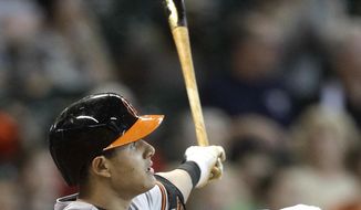 Baltimore Orioles&#x27; Manny Machado hits a grand slam to left field scoring Jonathan Schoop, David Lough, and Nick Markakis during the sixth inning of a baseball game against the Houston Astros, Sunday, June 1, 2014, in Houston. (AP Photo/Patric Schneider)