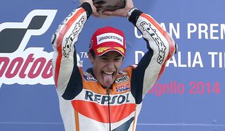 Honda rider Marc Marquez, of Spain, sticks his tongue out as he celebrates on the podium after winning the Italian Moto GP, at the Mugello race circuit, in Scarperia, Italy, Sunday, June 1, 2014. (AP Photo/Antonio Calanni)