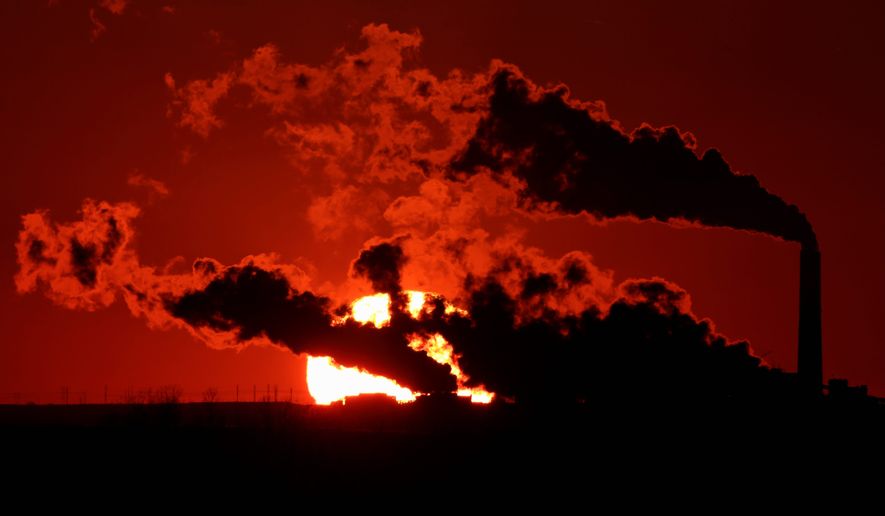 Steam from the Jeffrey Energy Center coal-fired power plant near St. Marys, Kan., is silhouetted against the setting sun on March 8, 2014. (Associated Press) **FILE**
