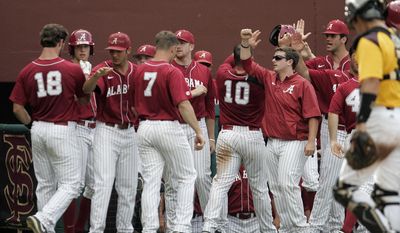 Alabama&#x27;s Wade Wass (10) and Austen Smith (18) celebrate with their teammates after scoring off a double by Casey Hughston against Kennesaw State in the fourth inning of an NCAA regional college baseball game on Sunday,  June 1, 2014, in Tallahassee, Fla. (AP Photo/Steve Cannon)
