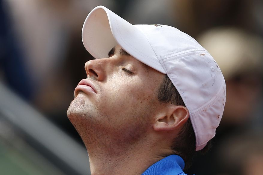 John Isner of the U.S. misses a return during the fourth round match of the French Open tennis tournament against Tomas Berdych of the Czech Republic at the Roland Garros stadium, in Paris, France, Sunday, June 1, 2014. Berdych won in three sets 6-4, 6-4, 6-4. (AP Photo/Darko Vojinovic)