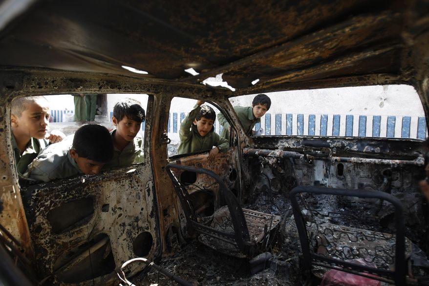FILE – This May 27, 2014, file photo shows Yemeni boys looking at a vehicle destroyed during a police raid on an al-Qaida militants&#39; hideout in the Arhab region, north of Sanaa, Yemen, which resulted in the death of five militants and six soldiers. According to the Obama administration’s most recent terrorism report, released by the State Department in late April, al-Qaida&#39;s core leadership has been degraded, limiting its ability to launch attacks and lead its followers. This has resulted in more autonomous and more aggressive affiliates, notably in Yemen, Syria, Iraq, northwest Africa and Somalia, according to the report, which recorded a 43 percent increase in terrorist attacks worldwide from 2012 to 2013. (AP Photo/Hani Mohammed)
