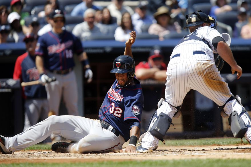 Minnesota Twins&#x27; Aaron Hicks, left, scores past New York Yankees catcher Brian McCann, right, on a single by Minnesota Twins&#x27; Trevor Plouffe during the third inning of a baseball game on Sunday, June 1, 2014, in New York. (AP Photo/Jason DeCrow)