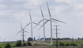 Wind turbines stand in a field, Monday, June 2, 2014, in Adair, Iowa. Iowa utility officials say the Obama administration&#x27;s ambitious plan to cut carbon dioxide emissions from power plants is likely to increase costs. Iowa utilities invested heavily in wind power over the past decade and improved the efficiency of existing power plants. (AP Photo/Charlie Neibergall)