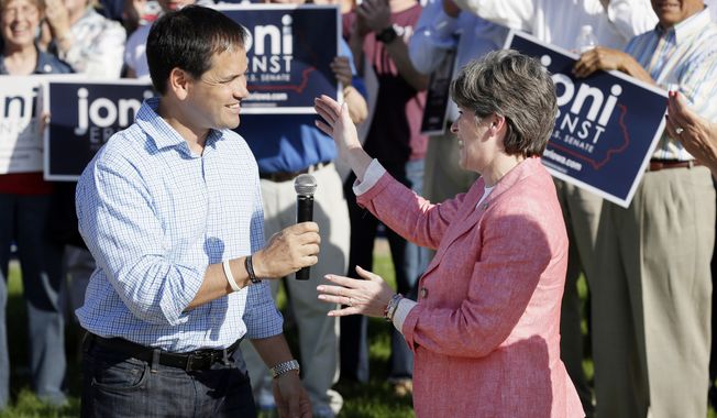 U.S. Sen. Marco Rubio, R-Fla., is greeted by Iowa Republican senatorial candidate Joni Ernst, right, before speaking at a rally with Ernst supporters, Monday, June 2, 2014, in Urbandale, Iowa. (AP Photo/Charlie Neibergall)