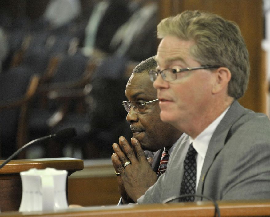 Rep. Thomas Stallworth III, left, D-Detroit, left, assumes a prayerful position while colleague Rep. John Walsh, R-Livonia speaks tothe senate committee on Government Operations on the bills associated with easing Detroit's bankruptcy in Lansing, Mich., Tuesday, June 3, 2014. Michigan's Senate approved on Tuesday spending $195 million to help prevent steeper cuts in Detroit retiree pensions, linking the state with a deal designed to shield valuable city-owned art from being sold and resolve the largest public bankruptcy in U.S. history. The (AP Photo/Detroit News, Dale G. Young) DETROIT FREE PRESS OUT; HUFFINGTON POST OUT. MANDATORY CREDIT