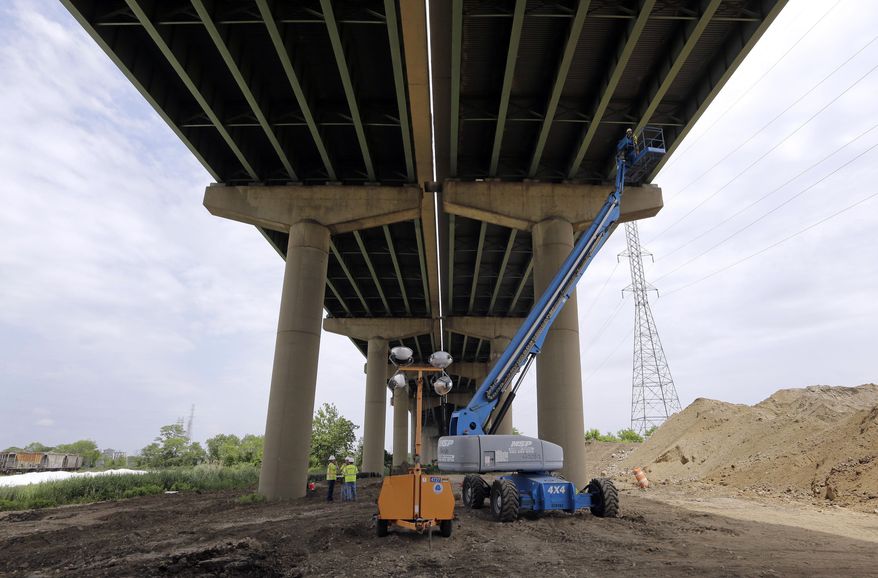 A worker inspects the underside of the Interstate 495 bridge over the Christina River near Wilmington, Del., Tuesday, June 3, 2014, after it was closed due to the discovery of four tilting support columns. The closure created heavier-than-normal traffic conditions for motorists on Interstate 95, a major East Coast artery. The bridge normally carries about 90,000 vehicles a day. (AP Photo/Patrick Semansky)