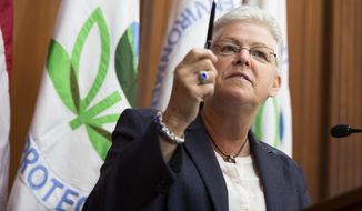** FILE ** Environmental Protection Agency (EPA) Administrator Gina McCarthy holds up a pen before signing new emission guidelines during an announcement of a plan to cut carbon dioxide emissions from power plants by 30 percent by 2030, Monday, June 2, 2014, at EPA headquarters in Washington.  (AP Photo/ Evan Vucci)