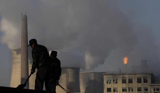 ** FILE ** In this Nov. 30, 2007, file photo, backdrop by cooling towers of a power plant and chemical factory, miners shovel coal at a mine in Xiahuayuan county, north China&#x27;s Hebei province. (AP Photo/Oded Balilty, File)
