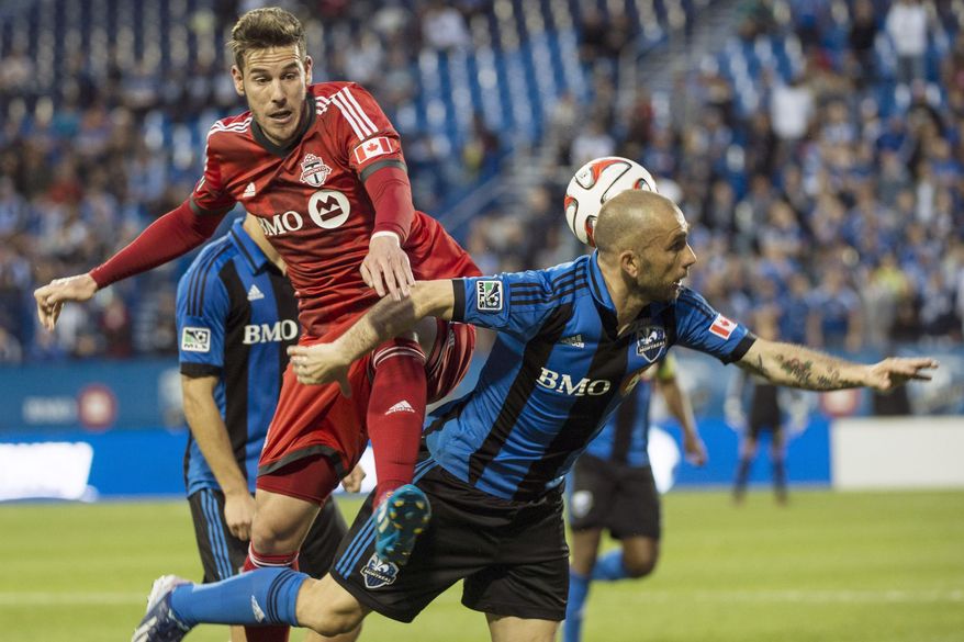 Toronto FC's Alvaro Rey leaps onto Montreal Impact's Marco Di Vaio during the first half of the Voyageurs Cup, Wednesday, June 4, 2014 in Montreal. (AP Photo/The Canadian Press, Paul Chiasson)