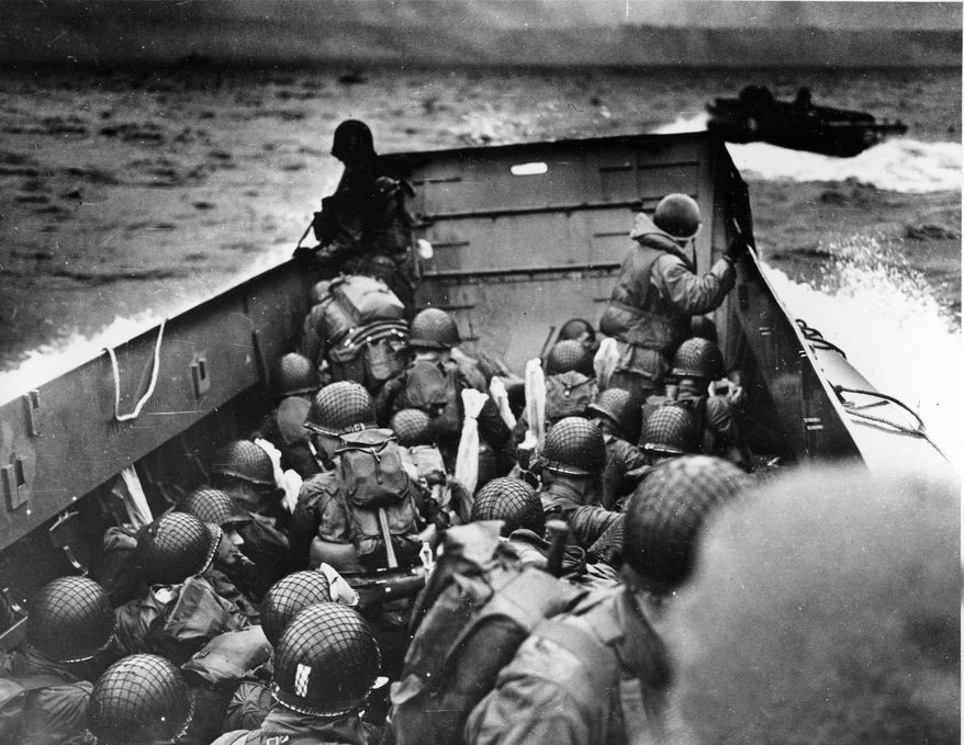 In this photo provided by the U.S. Coast Guard, a U.S. Coast Guard landing barge, tightly packed with helmeted soldiers, approaches the shore at Normandy, France, during initial Allied landing operations, June 6, 1944. These barges ride back and forth across the English Channel, bringing wave after wave of reinforcement troops to the Allied beachheads. (AP Photo)