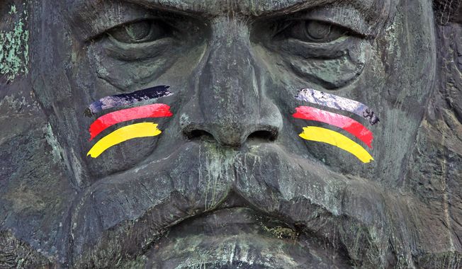 The monument of German philosopher, economist, and revolutionary socialist Karl Marx is painted with German national colors as an advertisement for the upcoming soccer World Cup tournament in Brazil, in Chemnitz, eastern Germany, Friday, June 6, 2014. (AP Photo/dpa,Jan Woitas) ** FILE **