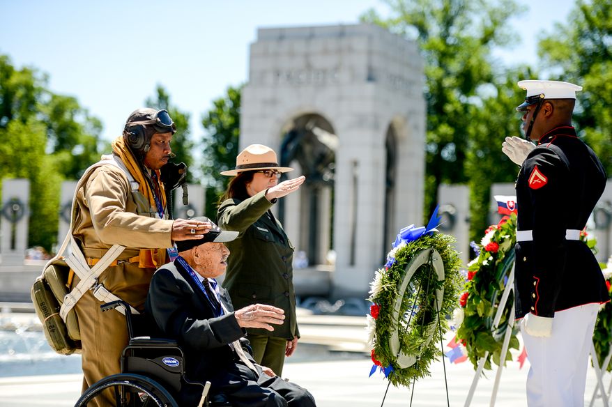 Park Service Historian John McCaskill, left, National Mall Deputy Superintendent Karen Cucurullo, third from left, salute with World War II veteran Air Force Buck Sgt. Henry Mendoza, 94, of Ontario, Calif., second from left, during a wreath laying ceremony for the 70th anniversary commemoration ceremony of D-Day at the National World War II Memorial on the National Mall, Washington, D.C., Friday, June 6, 2014. (Andrew Harnik/The Washington Times)