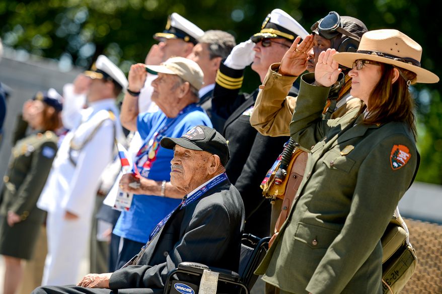 Park Service Historian John McCaskill, second from right, National Mall Deputy Superintendent Karen Cucurullo, right, and others salute next to World War II veteran Air Force Buck Sgt. Henry Mendoza, 94, bottom center, of Ontario, Calif. as taps is played for a 70th anniversary commemoration ceremony of D-Day at the National World War II Memorial on the National Mall, Washington, D.C., Friday, June 6, 2014. (Andrew Harnik/The Washington Times)