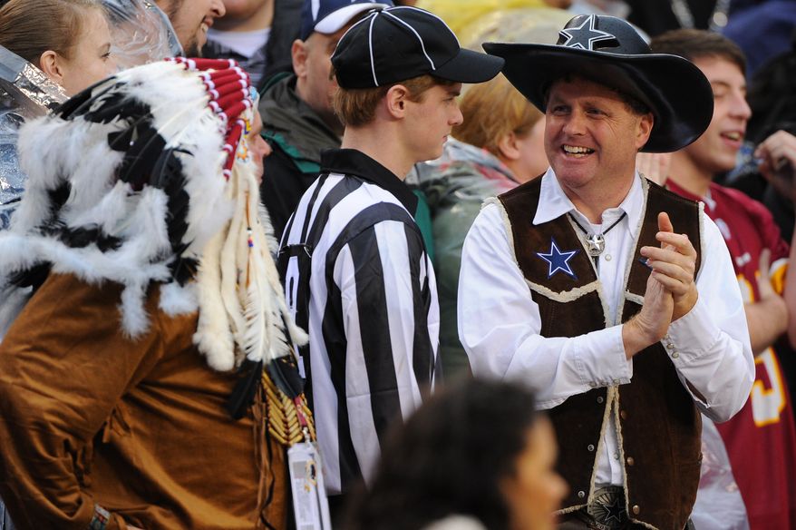A Cowboys fan celebrates in front of a Redskins fan during a break in action as his team marches the ball downfield in the fourth quarter at FedExField, Landover, Md., Dec. 22, 2013. (Preston Keres/Special for The Washington Times)