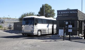 A bus leaves the entrance of the U. S. Border Patrol facility on Saturday, June 7, 2014 in Nogales, Ariz. Arizona officials said they are rushing federal supplies to this makeshift holding center in the southern part of the state that&#39;s housing hundreds of migrant children and is running low on the basics. (AP Photo/Brian Skoloff)