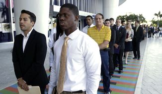 FILE - In this Wednesday, Oct. 23, 2013, file photo, Luis Mendez, 23, left, and Maurice Mike, 23, wait in line at a job fair held by the Miami Marlins, at Marlins Park in Miami. Employers added a scant 74,000 jobs in December after averaging 214,000 in the previous four months. The Labor Department said Friday, Jan. 10, 2014, that the unemployment rate fell from 7 percent in November to 6.7 percent, its lowest level since October 2008. But the drop occurred mostly because many Americans stopped looking for jobs. Once people without jobs stop looking for one, the government no longer counts them as unemployed. (AP Photo/Lynne Sladky, File)