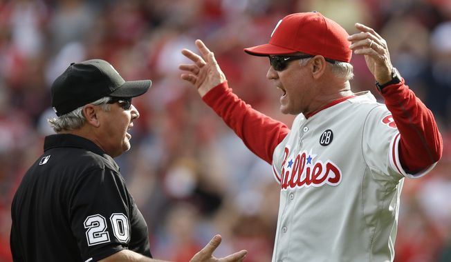 Philadelphia Phillies manager Ryne Sandberg (23) argues a reviewed call at home with umpire Tom Hallion (20) in the sixth inning of a baseball game against the Cincinnati Reds, Saturday, June 7, 2014, in Cincinnati. Sandberg was ejected from the game. (AP Photo/Al Behrman)