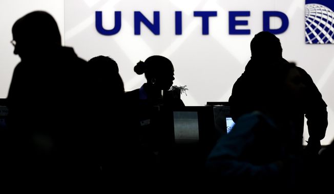 In this Saturday, Dec. 21, 2013, file photo, travelers check in at the United Airlines ticket counter at Terminal 1 in O&#x27;Hare International Airport in Chicago. (AP Photo/Nam Y. Huh, File)