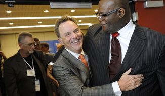 The Rev. Ronnie Floyd, center, of Cross Church in northwest Arkansas, hugs The Rev. Dwight McKissic, right, of Cornerstone Baptist Church in Arlington, Texas, after Floyd was elected the new president of the Southern Baptist Convention during its annual meeting Tuesday, June 10, 2014, in Baltimore. Floyd received 52 percent of votes cast by delegates to the annual meeting of the nation&#39;s largest Protestant denomination. (AP Photo/Steve Ruark)