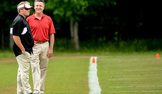 Former NFL head coach and current ESPN analyst Jon Gruden, left, talks with Washington Redskins General Manager Bruce Allen, right, on the sideline during organized team activities at Redskins Park, Ashburn, Va., Wednesday, June 11, 2014. (Andrew Harnik/The Washington Times)