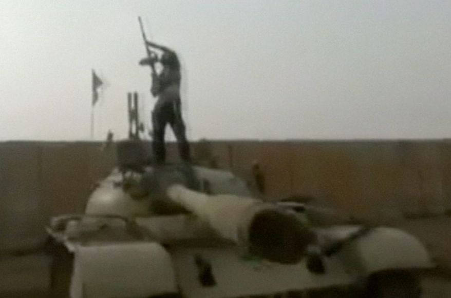 mujahid: A militant looms over a compound abandoned by Iraqi troops near Tikrit. Counterterrorism officials say the rarely seen Abu Bakr al-Baghdadi may be the most dangerous terrorist leader in the post-bin Laden world. (Associated Press)