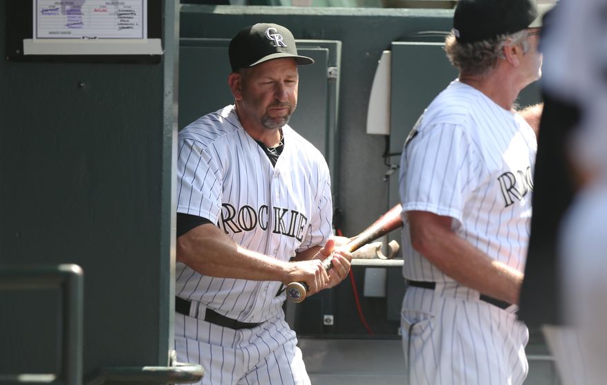 Upset over being ejected from the game, Colorado Rockies manager Walt Weiss grabs a bat on the way to smashing it against the wall in the team's dugout on the way to the showers against the Atlanta Braves in the eighth inning of the Rockies' 10-3 victory in a baseball game in Denver on Thursday, June 12, 2014. Weiss was ejected for arguing after the rockies' Corey Dickerson was hit by a pitch thrown by Braves relief pitcher David Carpenter. (AP Photo/David Zalubowski)