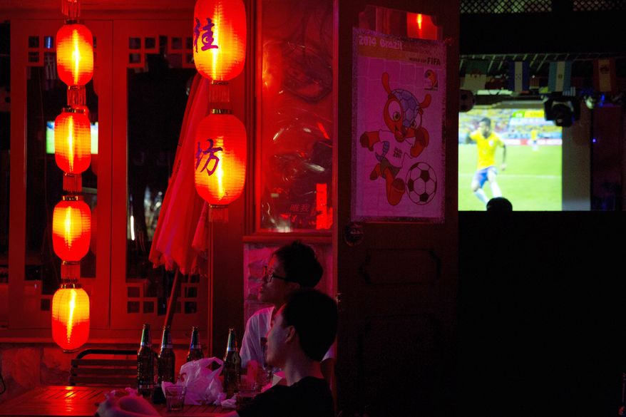 Chinese soccer fans watch the opening match of the 2014 World Cup between Brazil and Croatia, at a bar in Beijing, China, Friday, June 13, 2014. (AP Photo/Ng Han Guan)